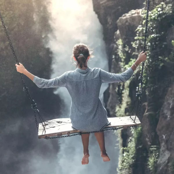 Lylusio Reiki Astrologie- Une femme se balançant devant une cascade zen