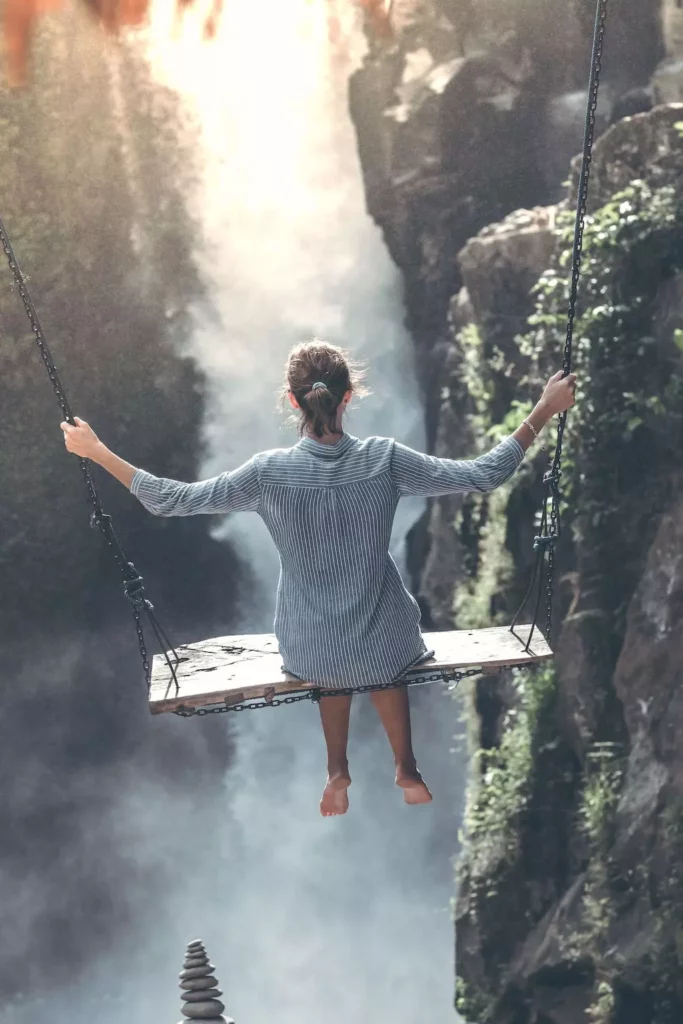 Lylusio Reiki Astrologie- Une femme se balançant devant une cascade zen
